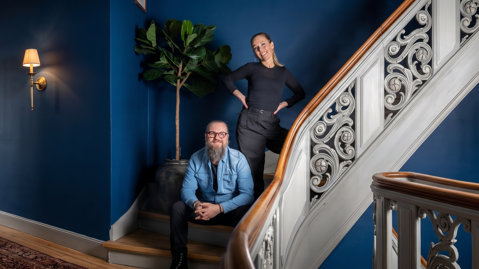 Allan og Betina Donde på trappe i Foyer med blå vægge